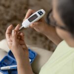 woman with diabetes checking blood sugar, which can affect oral health, gum disease, dry mouth, dental care, Dallas Center for Oral Health & Wellness