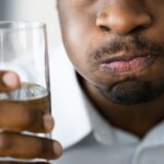 man with dry mouth from autoimmune disease drinking water