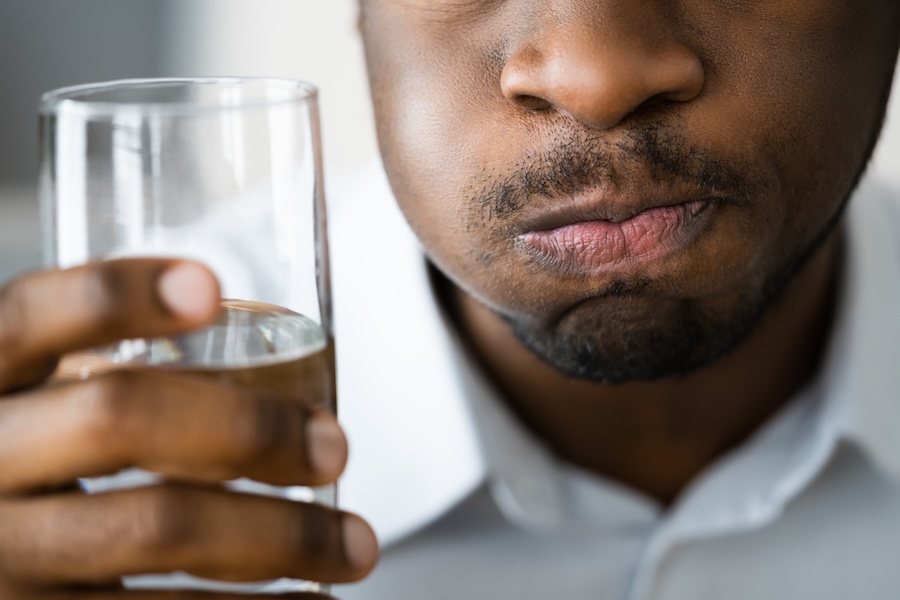 man with dry mouth from autoimmune disease drinking water