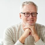 man with glasses and dry mouth smiling