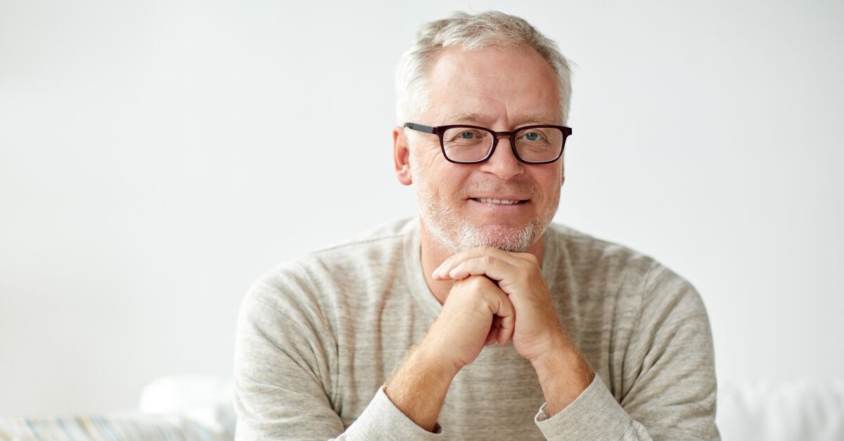 man with glasses and dry mouth smiling